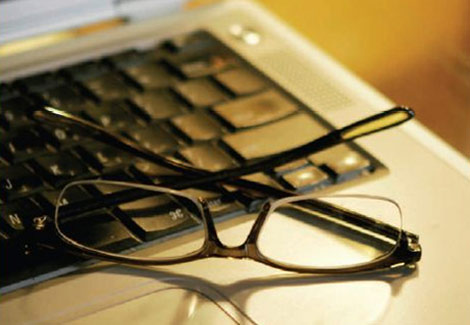 A pair of glasses sitting on top of a keyboard.